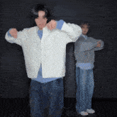 a man in a white jacket and a man in a grey sweater are dancing