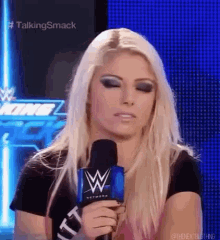 a woman is holding a microphone in front of her face .
