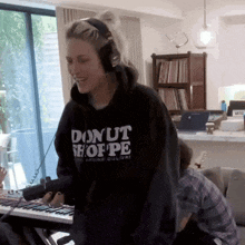 a woman wearing headphones and a donut shope hoodie
