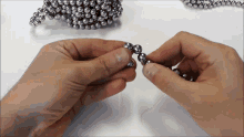 a person is holding a string of metal beads