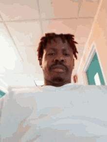 a man with dreadlocks and a beard is laying on a bed