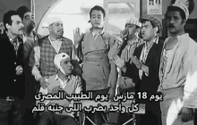 a group of men standing around a man in a wheelchair with arabic writing on the bottom