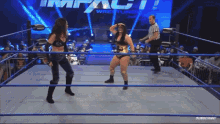 two women are standing in a wrestling ring with the word impact wrestling behind them