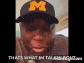 a man wearing a hat with the letter m on it is making a funny face .