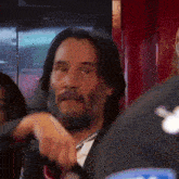 a man with a beard is wearing a suit and tie while holding a steering wheel .