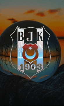 a logo for bjk 1903 is displayed in a glass ball