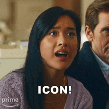 a woman in a purple sweater says icon in front of a man in a suit