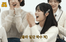 a group of girls are laughing and one of them has a clip in her hair that says ' o ' on it
