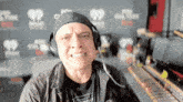 a man wearing headphones making a funny face in front of a wall that says iheart radio