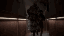 a blurred image of a person walking down a dark hallway