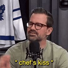 a man talking into a microphone with chef 's kiss written in yellow