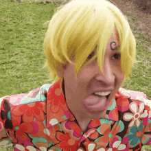 a man wearing a yellow wig has a tattoo on his forehead that says c