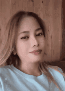 a woman with long blonde hair is wearing a blue shirt
