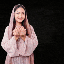 a woman wearing a pink hijab and a ring on her finger