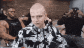 a man with a bald head is wearing a nike sweatshirt