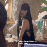 a woman with long black hair stands in front of a statue and says mi cara cuando le pertenezco only a dome