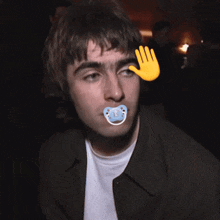 a man with a pacifier in his mouth and a hand behind his head