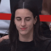 a woman with her eyes closed is wearing a black shirt and earrings