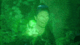 a woman in a black dress is surrounded by green light .