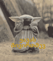 a picture of a baby yoda with foreign writing on the bottom of it