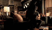 a man is sitting on a couch in a dark living room
