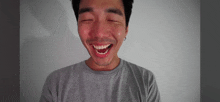 a man with a beard is smiling with his eyes closed and his mouth open