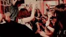 a large group of people are dancing in a room .