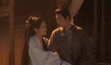 a man and a woman are standing next to each other .