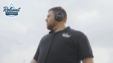 a man wearing headphones and a reliant plumbing logo