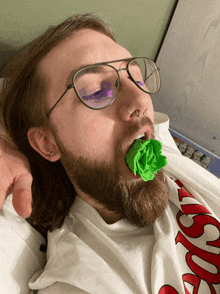 a man with glasses and a beard is laying on a bed