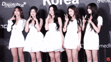 a group of girls are posing for a picture in front of a sign that says korea