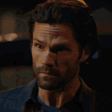 a man with a beard is looking at the camera