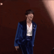 a man in a blue suit is standing on a stage .