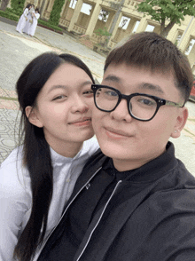 a boy and a girl are posing for a picture