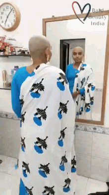 a woman with a shaved head looks at herself in a mirror