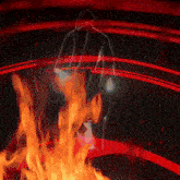 a silhouette of a person in a hooded jacket is surrounded by flames