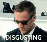a man wearing sunglasses and a suit has the word disgusting written on his face