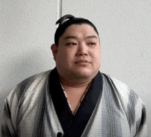 a man with a ponytail is wearing a striped robe
