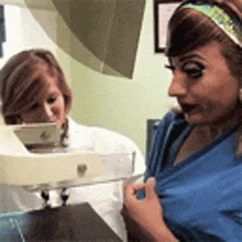 a woman in a blue scrub is getting an x-ray of her breast