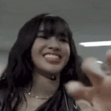 a close up of a woman 's face with a hand reaching out towards her .