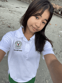 a girl taking a selfie wearing a polo shirt that says ' philippines ' on the front