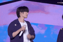 a man holding a microphone in front of a purple background that says t time