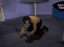 a man is kneeling down in a room with his head down