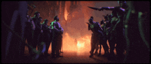 a group of men are standing in front of a fire