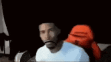 a man in a white shirt is making a funny face with his mouth wide open .