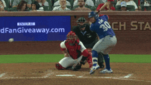 a blue jays baseball player swings his bat at a ball