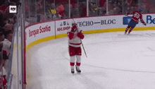 a hockey player stands on the ice in front of a banner for echo bloc
