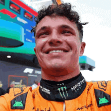 a man in a monster energy shirt smiles for the camera