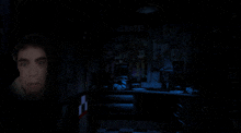 a man in a dark room with a celebrate sign on the wall