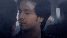 a man with a bandage on his head is kissing a woman on a plane .
